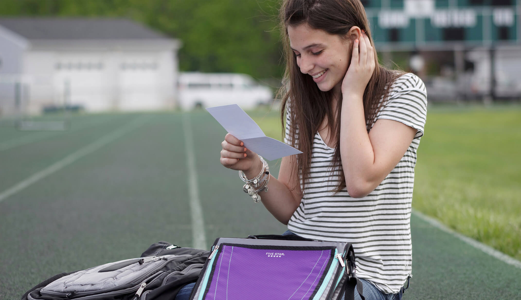 natural smile real girl smiling holding binder notes school branded UGC content shirt stripes